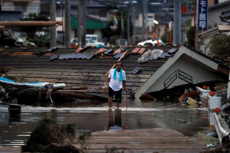 A local resident walks in front of submerged and destroyed houses in a flooded area in Mabi town in Kurashiki, Okayama Prefecture, Japan, July 8, 2018. (Reuters/Issei Kato)