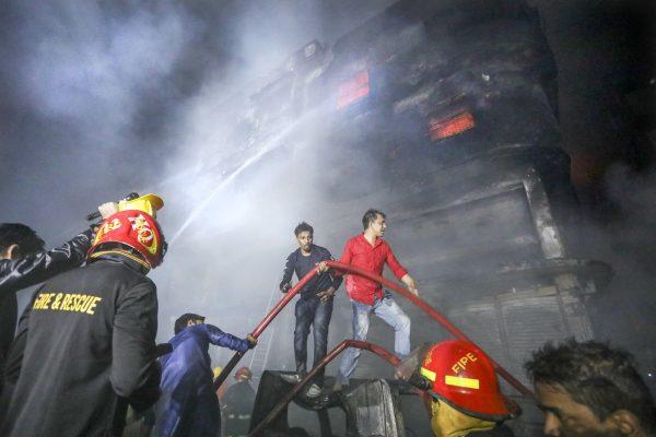 Locals and firefighters douse flames of a smoldering fire in a building in Dhaka, Bangladesh, on Feb. 21, 2019. (Photo/AP)