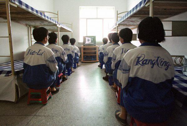 Falun Dafa practitioners are shown in Masanjia labour camp watching a video meant to “re-educate” them during a propaganda tour arranged by the camp authorities on May 22, 2001. (AP Photo/John Leicester)