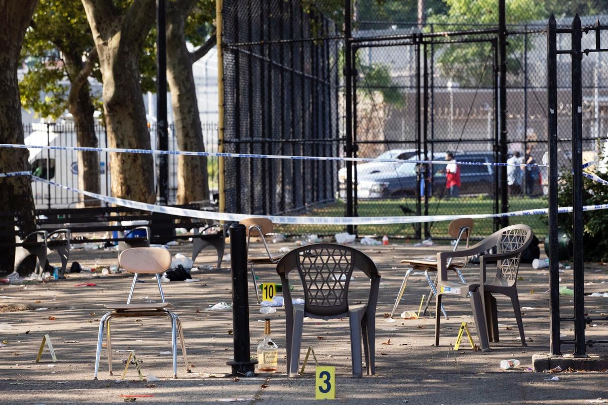 Yellow evidence markers are placed next to chairs at a playground in the Brownsville neighborhood of New York, Sunday, July 28, 2019. (AP Photo/Mark Lennihan)