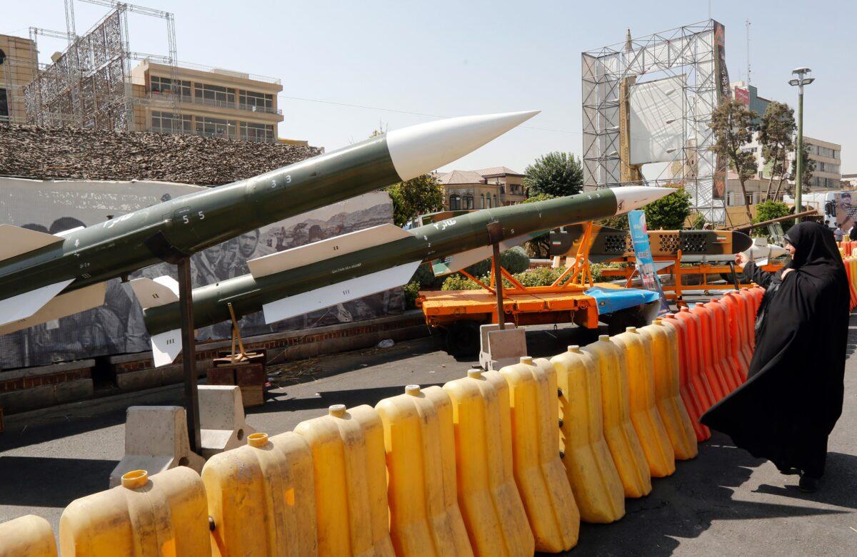 An Iranian woman looks at Taer-2 missile during a street exhibition, on Sept. 26, 2019. (Stringer/AFP via Getty Images)