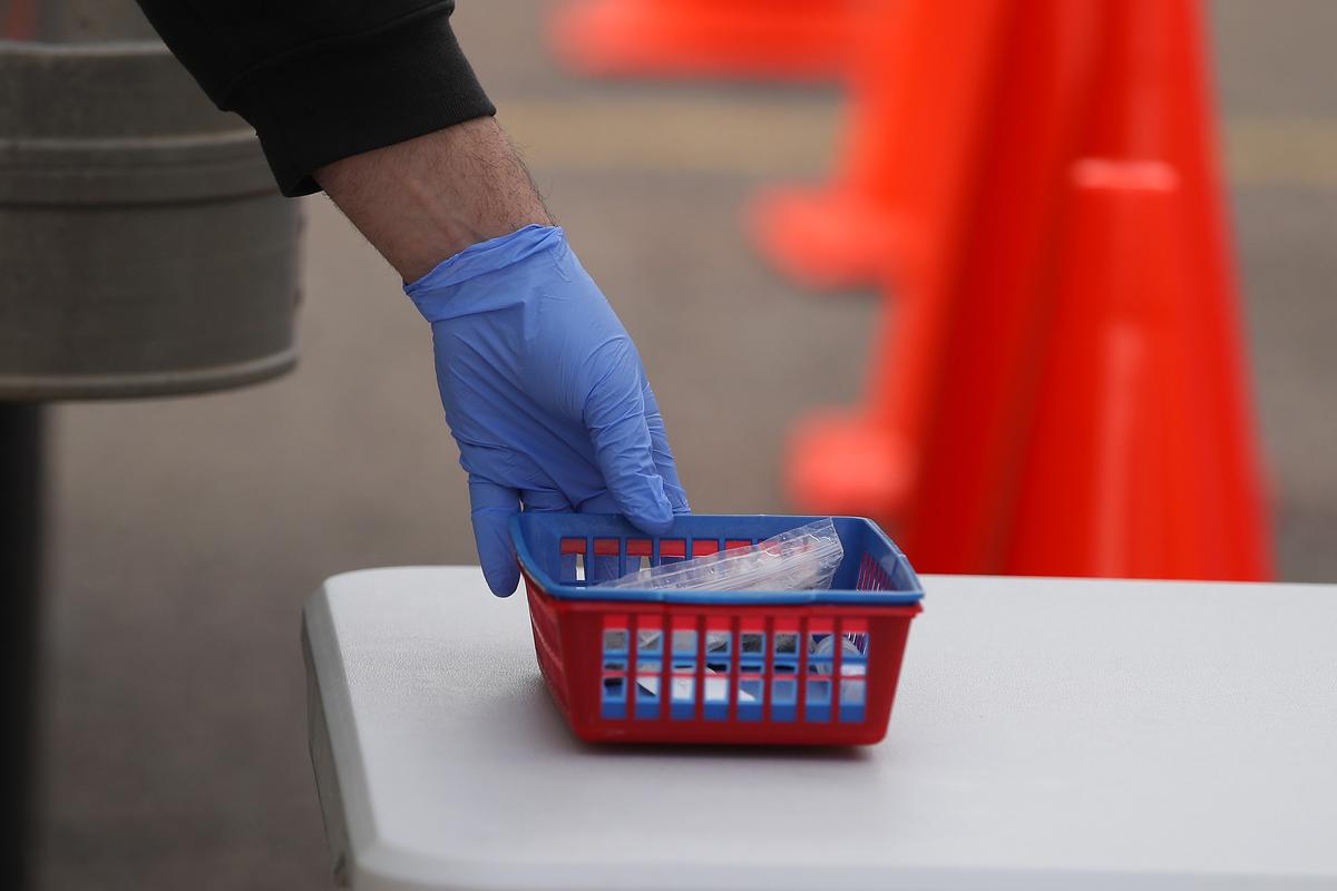 A drive through customer picks up a swab kit at a Rite Aid drive through testing site in Macomb, Mich., on April 21, 2020. (Gregory Shamus/Getty Images)